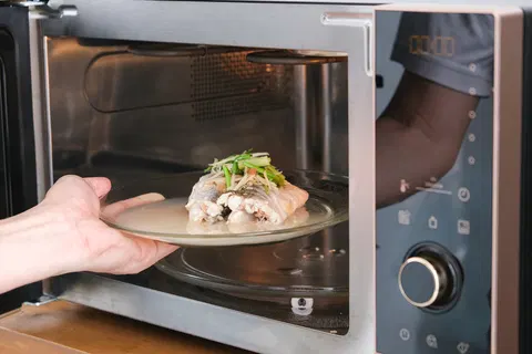 Cop fired and arrested after pulling gun on colleague who microwaved fish