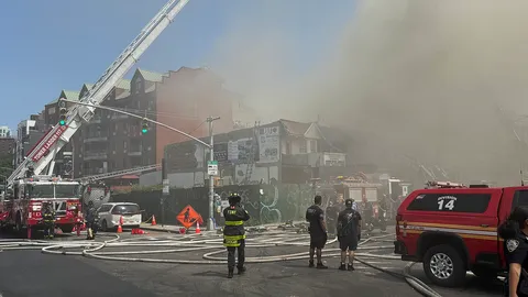 Nearly two dozen people injured as monster fire rips through wooden apartment block leaving resident trapped