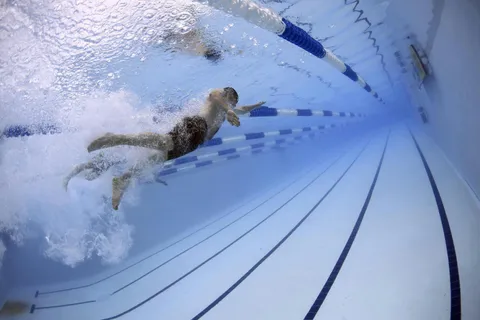 Visualizing how flutter kick vertical vortices generate propulsion and suppress body sway in swimmers