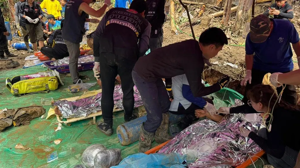 Rescuers free 4 men who had been trapped in a flooded Laos cave, search for 2 still missing